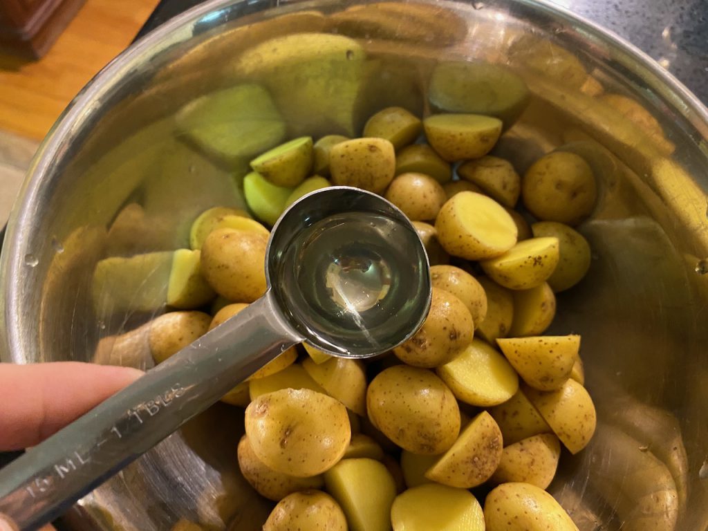 Adding oil to Yukon Gold potatoes