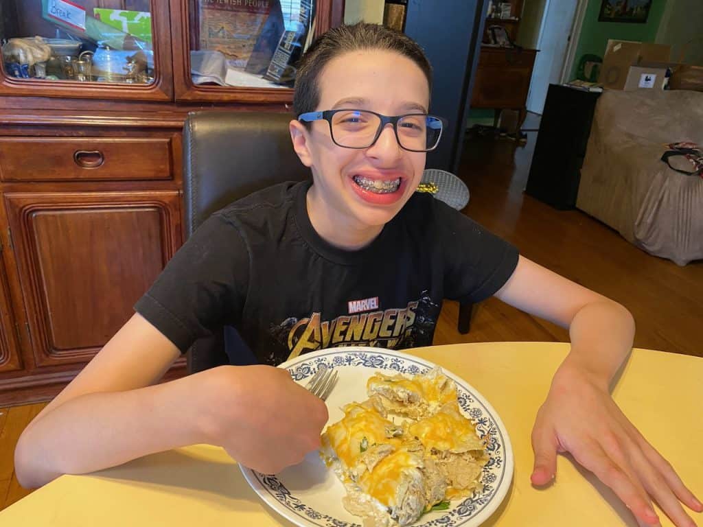 Kid enjoying Gluten Free Chicken Enchiladas Suizas