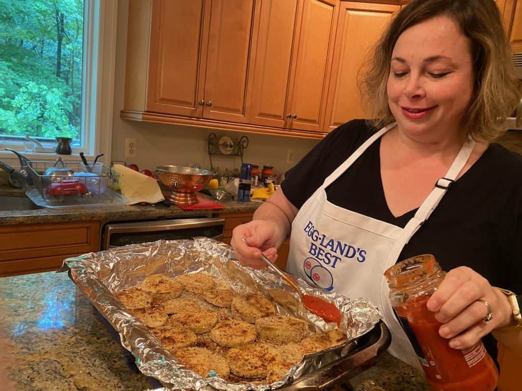 Putting on sauce on eggplant