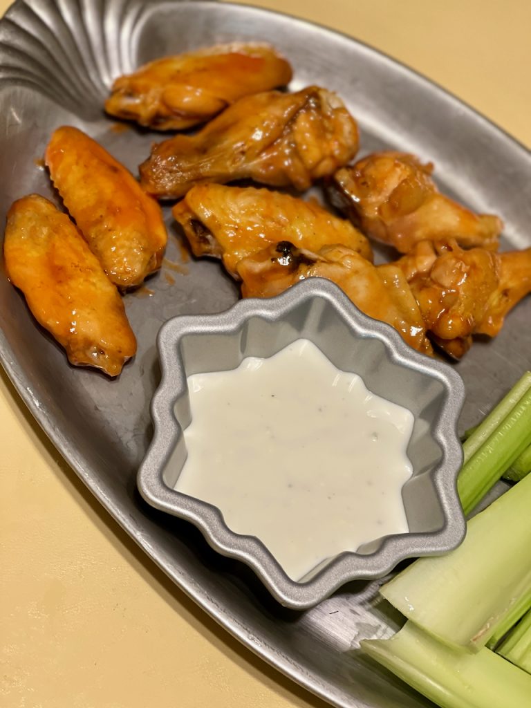 Air Fryer Spicy Buffalo Chicken Wings (Gluten Free) on a platter with blue cheese and celery