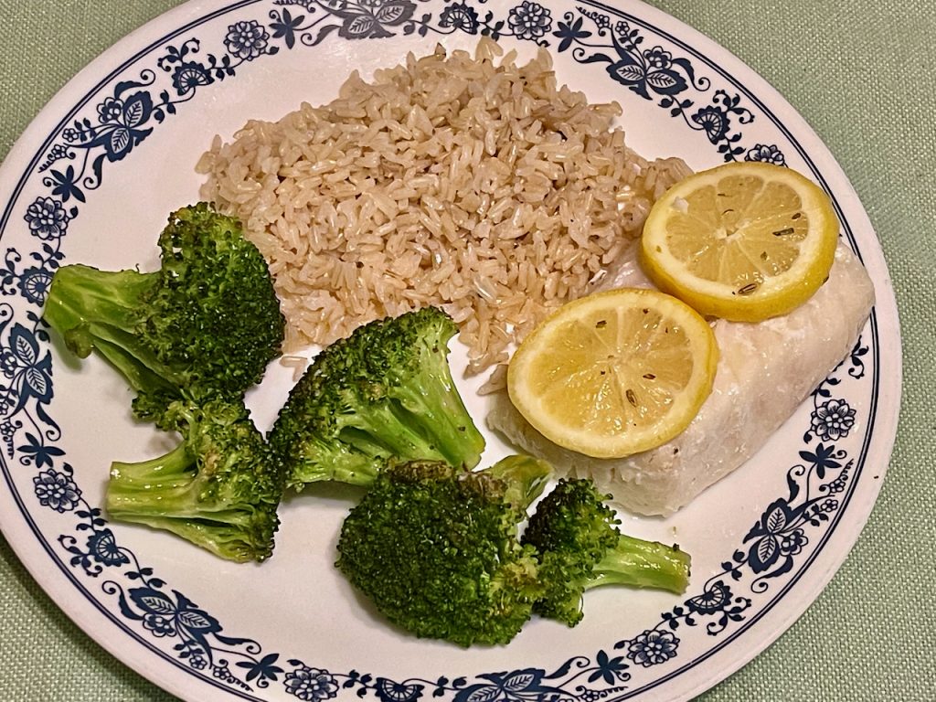 plate of roasted lemon cod and broccoli over rice