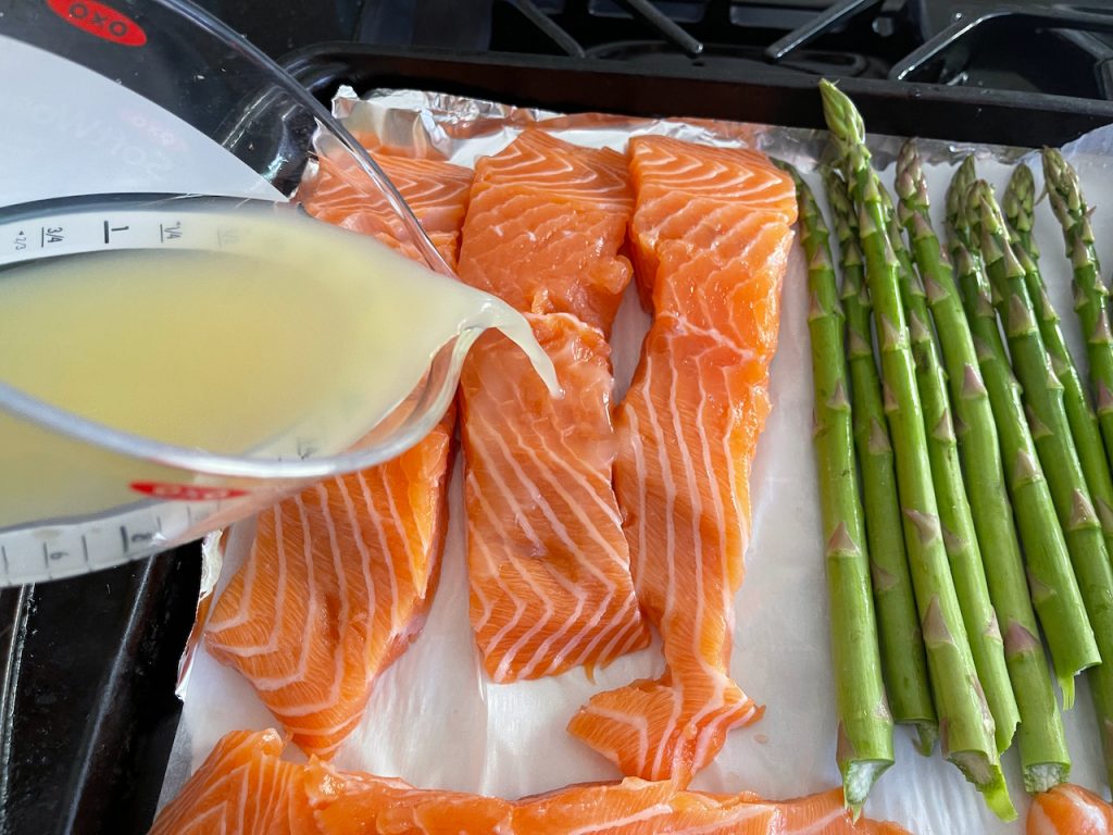 Pouring lime juice on salmon and veggies