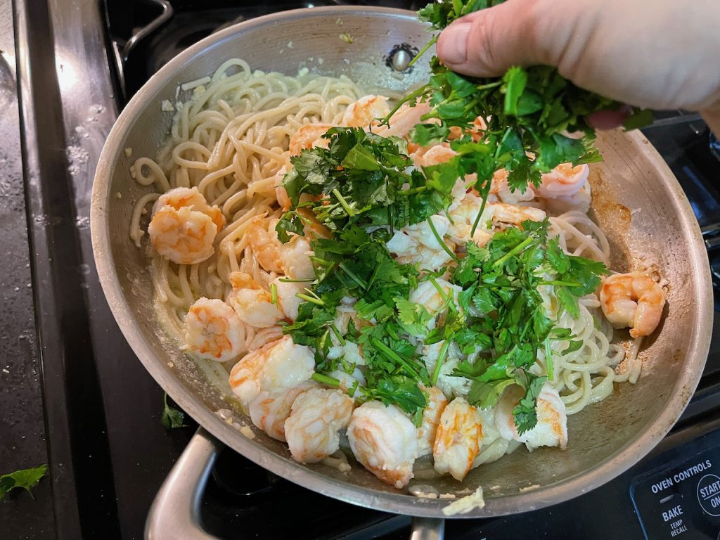 Adding parsley to pan