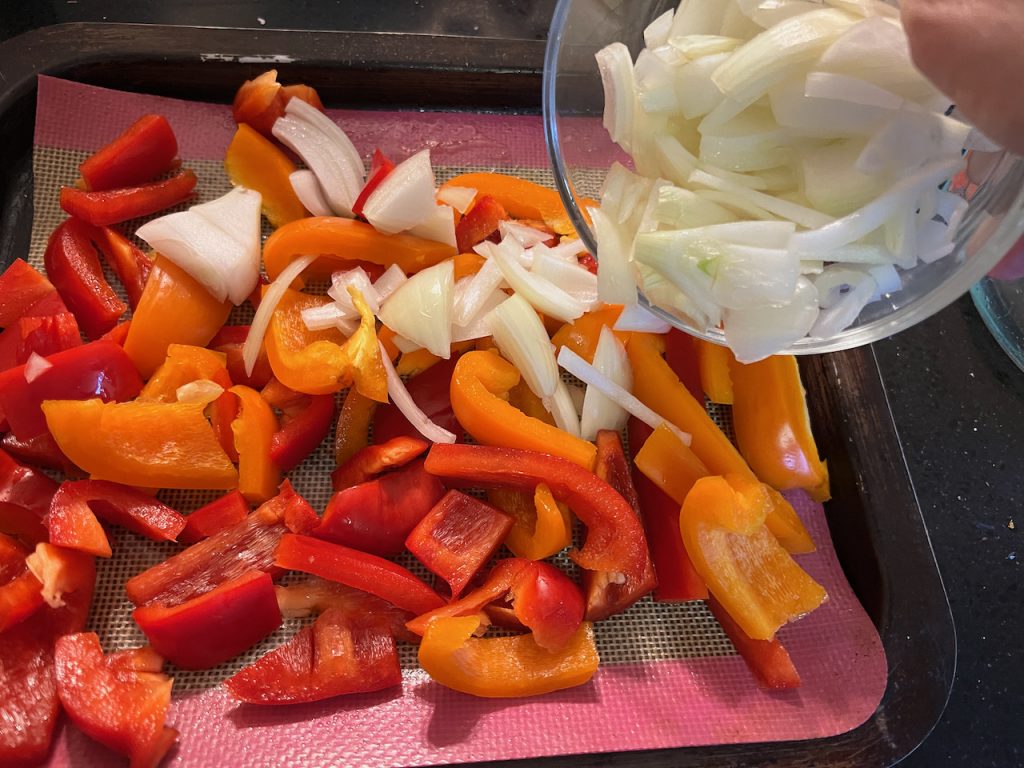 Adding cut peppers and onions to silicone mat