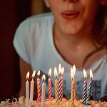 women blowing out birthday cake candles